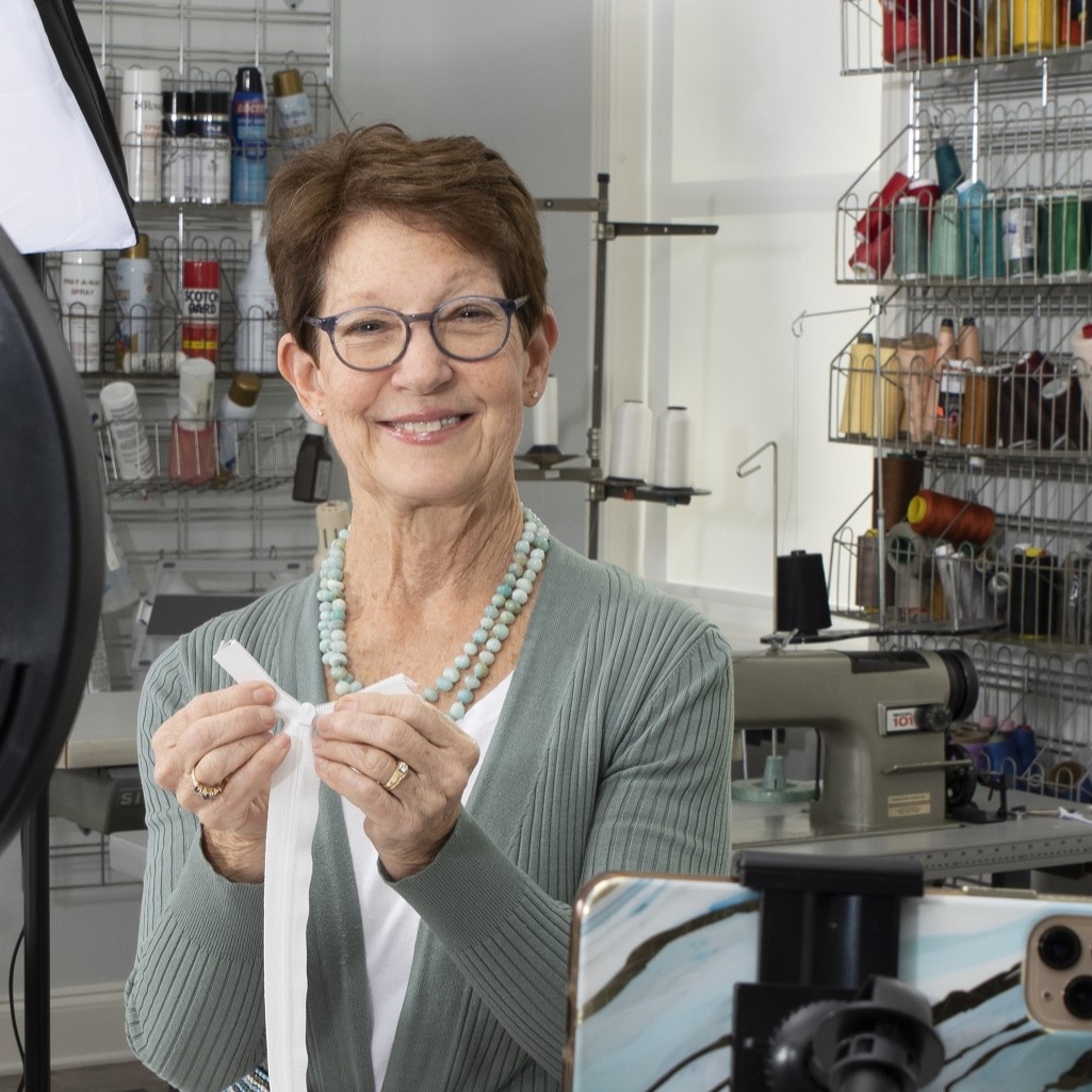 Donna inserting zipper slide onto zipper chain